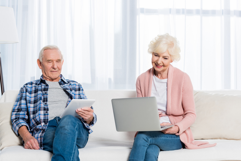 portrait-of-smiling-senior-wife-and-husband-using--BNWTSDM.jpg